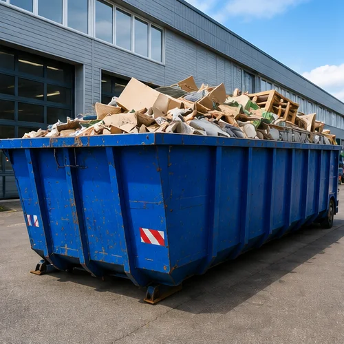 Benne de collecte de déchets d’entreprise devant un site professionnel